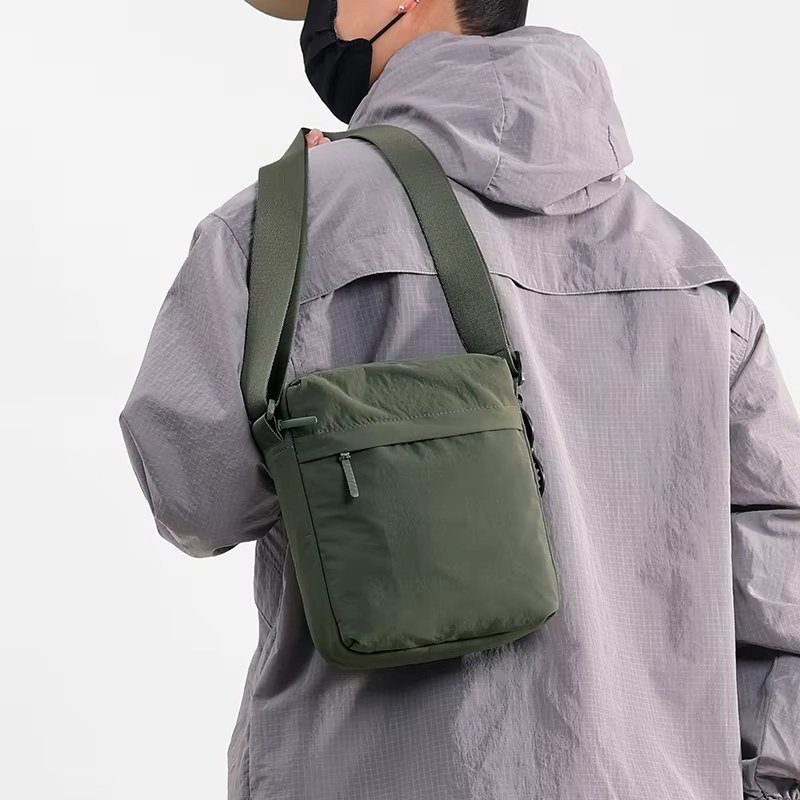 Army green nylon crossbody worn on the back