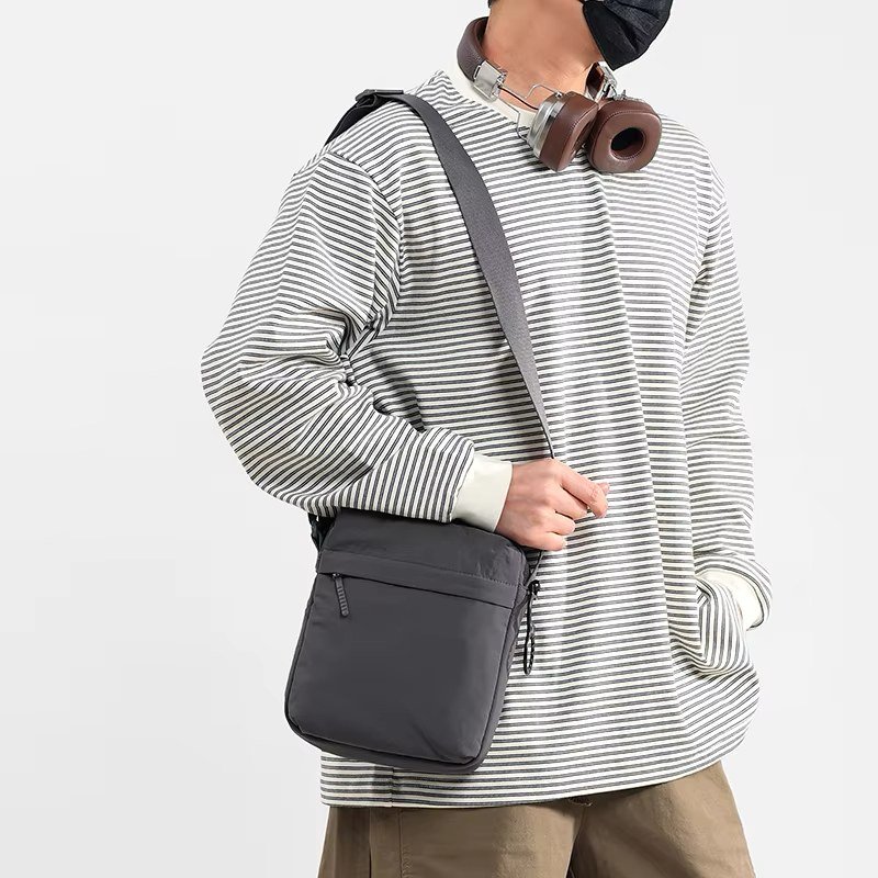 Dark grey nylon crossbody worn across the body